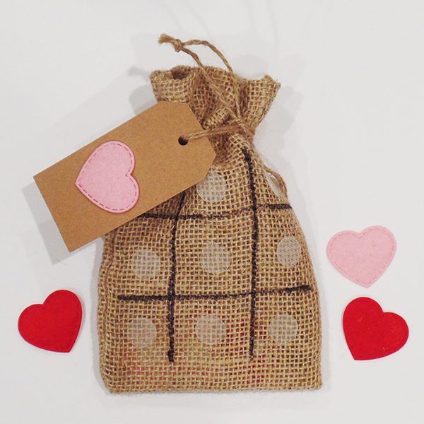 DIY tic-tac-toe burlap bag with red and pink heart shapes and Valentine's Day gift tag