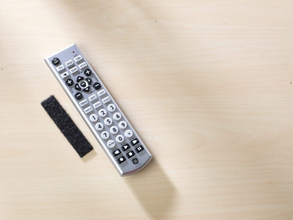TV remote control on table with VELCRO® Brand Sticky Back Strips