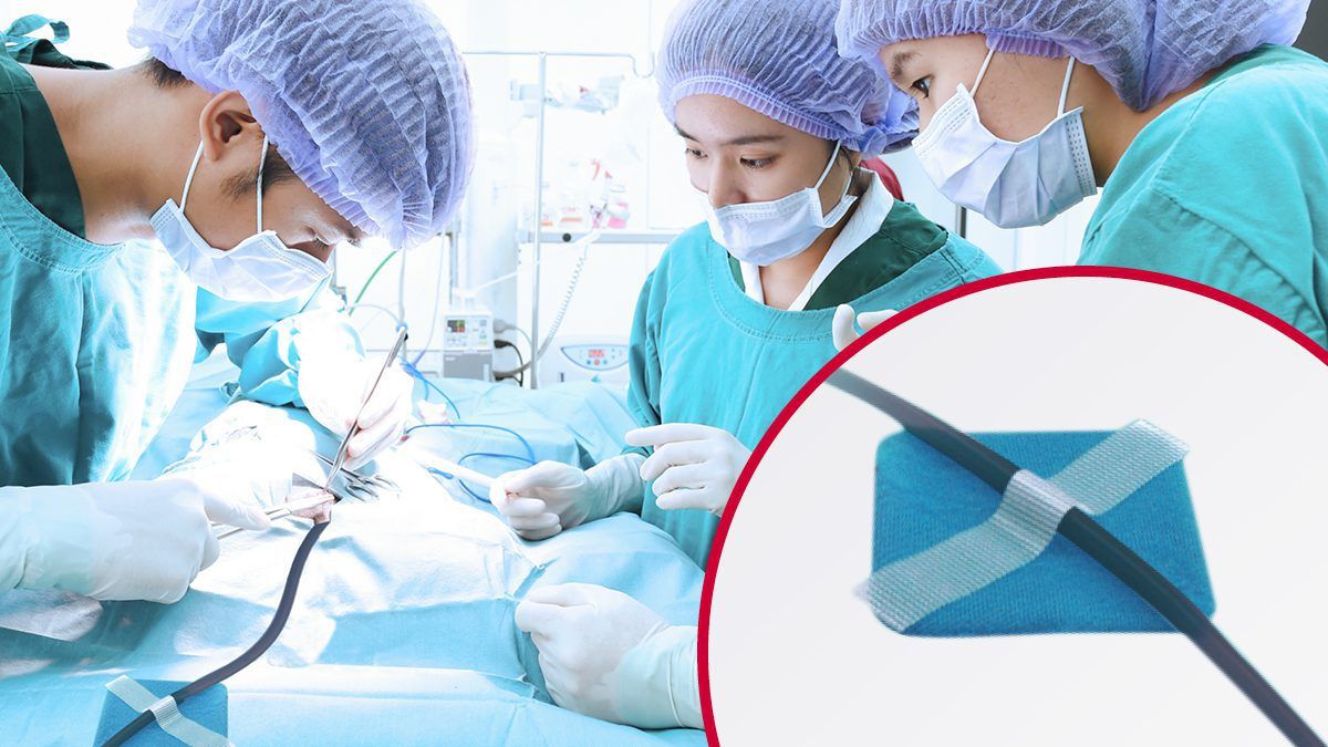 Surgeons operate while VELCRO® Brand hook and loop fasteners for surgical devices secure a medical tube in an inset view.