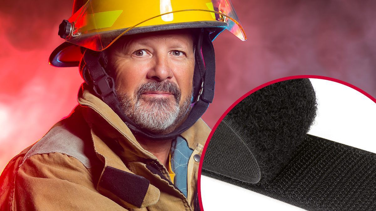 Firefighter in protective gear with a yellow helmet and tan jacket, featuring VELCRO® Brand hook and loop fasteners for secure equipment attachment, highlighting VELCRO® Brand solutions for emergency services, civilian protection and rugged outdoor applications.