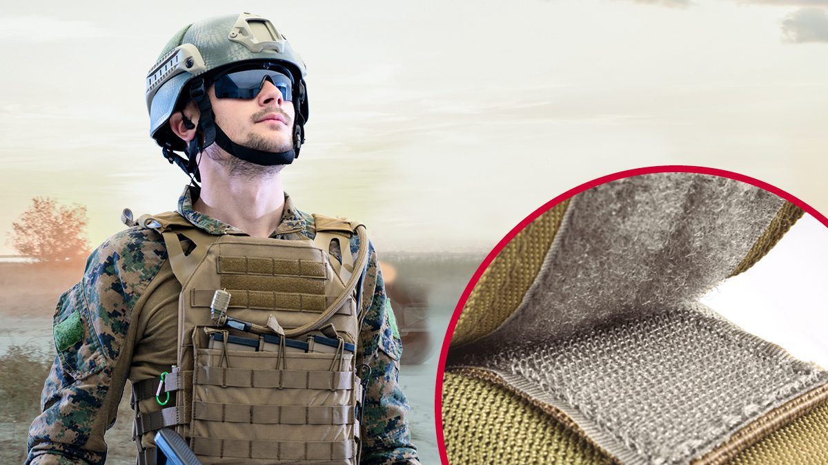 Close-up of a soldier in tactical gear featuring a helmet and a ballistic vest secured with VELCRO® Brand hook and loop fasteners, highlighting military fasteners, tactical gear, and secure attachment solutions using VELCRO® Brand products.