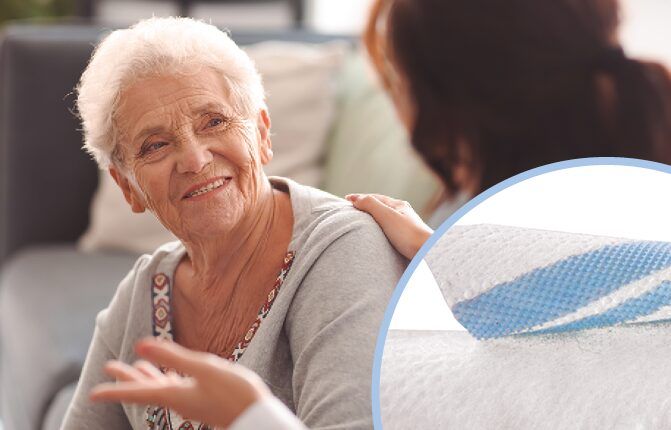 Elderly woman with carer. Soft VELCRO® Brand tab in corner for adult incontinence.