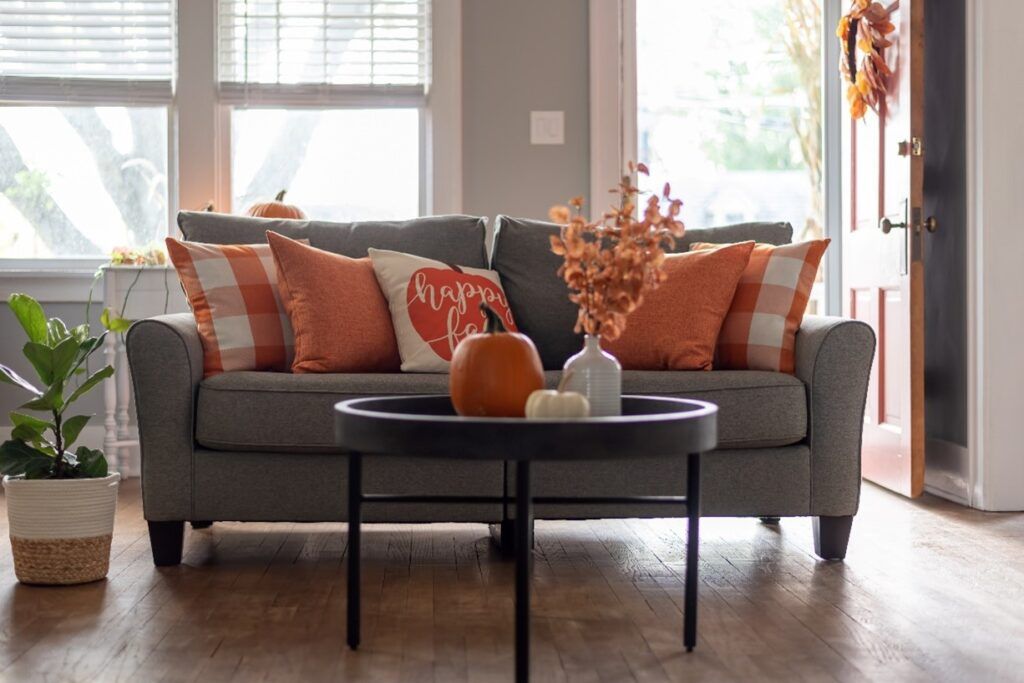 gray couch with orange fall pillows