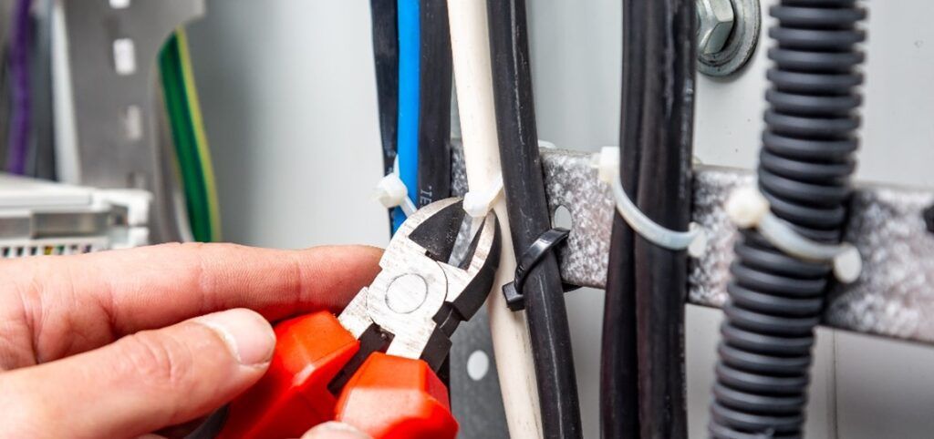 Wires with zip ties and a plyers with a red handle