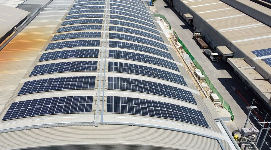 Solar panels mounted on a curved industrial roof using VELCRO® Brand fasteners.