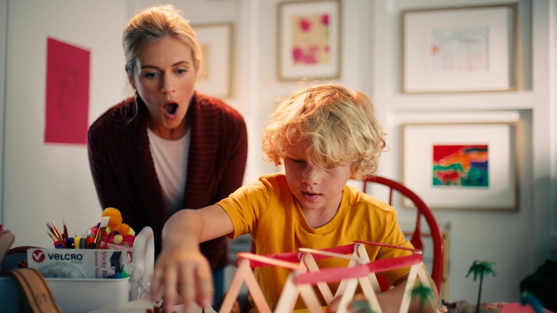 Mother and son crafting with VELCRO® Brand Sticky Back Dots and popsicle sticks.