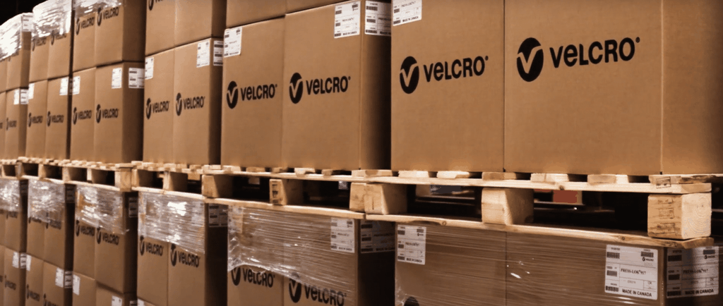 VELCRO® Brand product boxes stacked on pallets in warehouse for solar panel installation supply