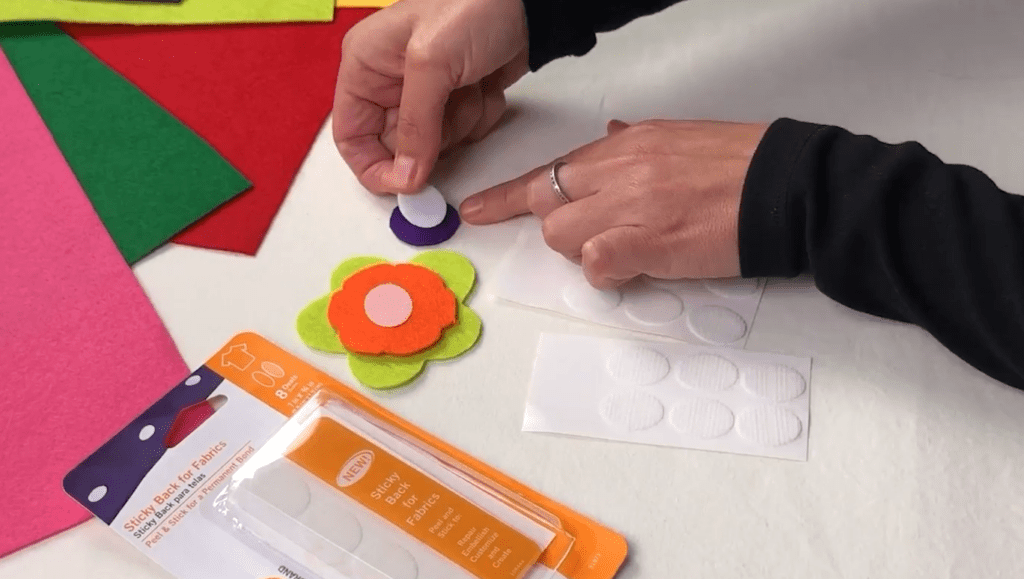 Hands sticking VELCRO® Brand Sticky Back for Fabrics to a circle for the center of a flower.