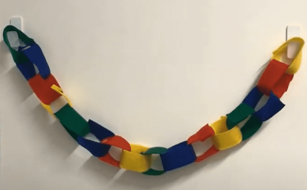 Handmade felt link garland hung on a wall.